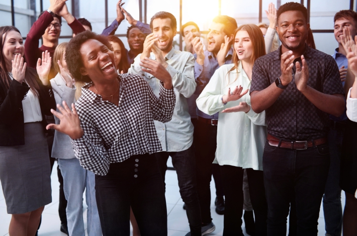 a group of diverse people in the workplace celebrating.